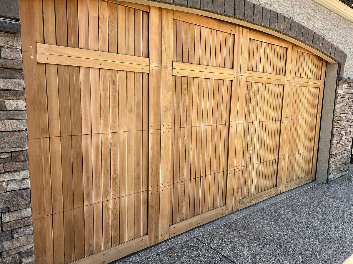Cedar sectional garage door after sanding, with panel joints visible